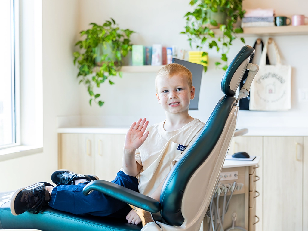 comprehensive pediatric dental services photo of boy waving